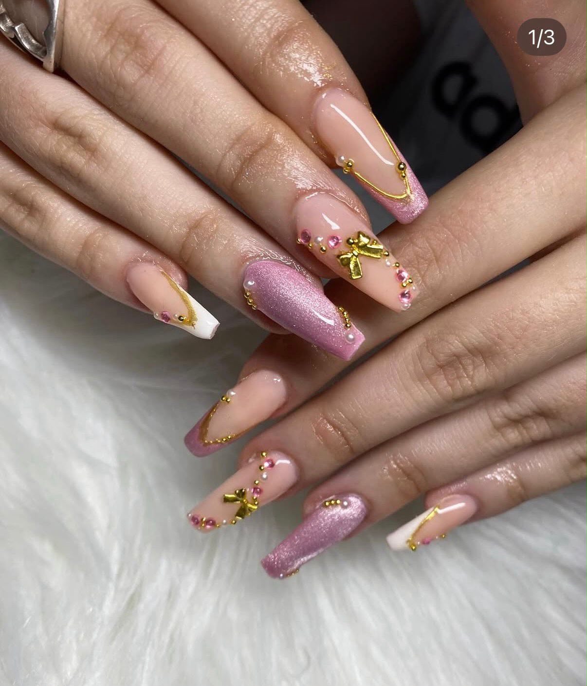 Diseño Coffin en tonos rosas con apliques dorados, perlas y lazos por Nails Dreams & Beauty